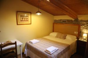 a bedroom with a bed with two towels on it at Senda Verde do Salnés in Portas