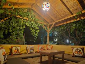 a patio with a couch and a table under a wooden ceiling at Tahtavilla Pansiyon in Cıralı