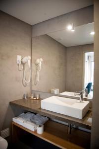 Agua d'Alma Hotel في فوز دو أريلهو: حمام مع حوض أبيض كبير ومرآة