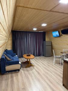 a living room with a blue couch and a table at Wooden House Martvili in Martvili