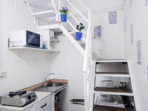 a kitchen with white shelves and a sink at Larimar in Almería