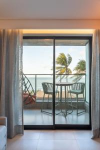 a dining room with a table and a view of the ocean at FLAT pé na areia frente mar com vista incrível, HYDE PARK 103 in João Pessoa