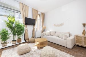 un soggiorno bianco con un divano e un tavolo di SUHU Berlin Apartments a Berlino