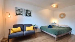 une chambre avec un lit et un canapé dans l'établissement Au Nouveau Boulonnais - 4 appartements charmants pour couples, familles et groupe d'amis, vieille ville et centre ville de Boulogne sur Mer, à Boulogne-sur-Mer