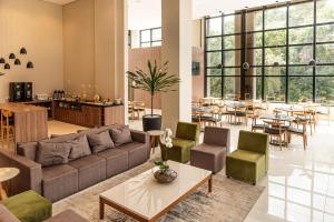 a living room with a couch and chairs and tables at Rio Hotel by Bourbon Maringá in Maringá