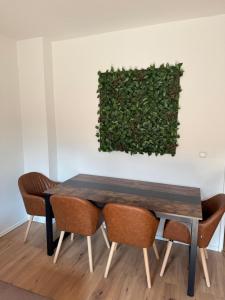 Modernes Apartment, Zentral Essen, Top Ausstattung في إيسن: طاولة طعام مع كراسي وجدار أخضر
