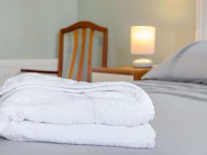 una pila de toallas blancas sentadas en una cama en 1 Bed in Broadstairs 89359, en Broadstairs
