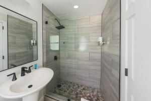 Un baño con lavabo blanco y ducha. en Beachside 1BR Apt - Walk to Hollywood Dania Beach, en Dania Beach