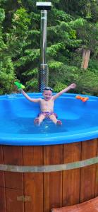 a young boy sitting in a swimming pool at Chata Turík in Turík