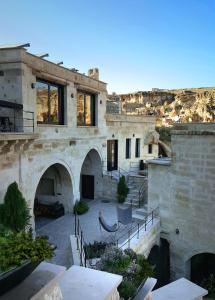 een stenen huis met een binnenplaats en een patio bij SOTA Cappadocia in Urgup