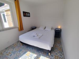 ein Schlafzimmer mit einem weißen Bett und einem Fenster in der Unterkunft La 08 maison de vacances in Fort-Mahon-Plage