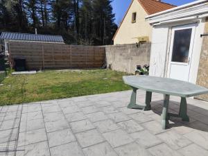 ein grüner Picknicktisch auf einer Terrasse in der Unterkunft La 08 maison de vacances in Fort-Mahon-Plage