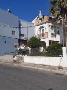 un bâtiment blanc au bord d'une rue dans l'établissement The Romance # 01, à Kavala