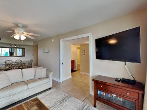 a living room with a couch and a flat screen tv at Regency Towers #302 West in Pensacola Beach