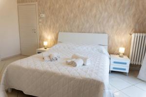 a bedroom with a white bed with towels on it at Luma Casa Vacanze in Gaeta