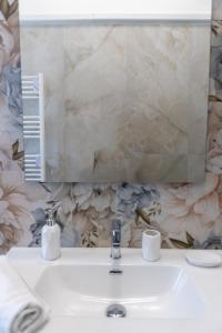 a bathroom with a sink with a mirror and a sink at Luma Casa Vacanze in Gaeta +34 photos