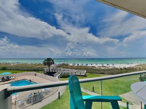 a view of the beach from a balcony with a chair at Regency Towers #302 West in Pensacola Beach