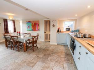 a kitchen and dining room with a table and chairs at Rosemary Cottage in Leyburn
