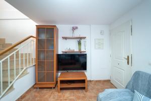 a living room with a staircase and a table at Adosado con piscina cerca de Castellón y Benicàssim a 10 min andando de la playa in Almazora