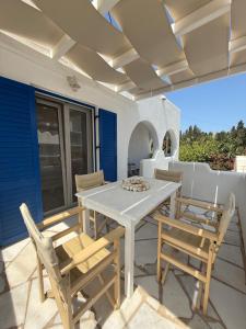 a white table and chairs on a patio at Central Parikia stay-Helios in Parikia