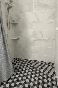 坦帕Green Castle Apartment in Tampa Near Airport and Busch Gardens的带淋浴的浴室以及黑白格子地板。