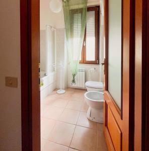 a bathroom with a toilet and a shower and a window at Casa Isabella in Nuoro