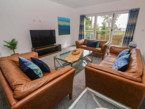 a living room with two leather couches and a television at Miramar in St Ives