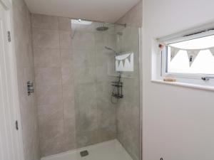 a bathroom with a shower with a glass door at Miramar in St Ives +41 photos