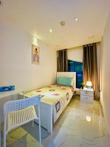 a bedroom with a bed and a chair in it at DSV Property in Abu Dhabi