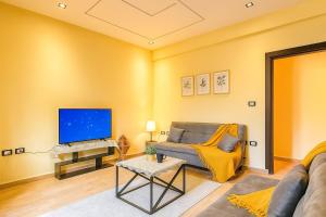 a living room with a couch and a tv at Stylish 2BR Flat - El Shorouk, Near Madinaty in Madīnat ash Shurūq