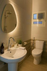 a bathroom with a sink and a toilet and a mirror at Stylish 2BR Flat - El Shorouk, Near Madinaty in Madīnat ash Shurūq +6 photos