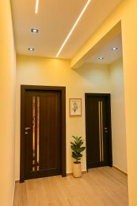 a hallway with two doors and a potted plant at Stylish 2BR Flat - El Shorouk, Near Madinaty in Madīnat ash Shurūq +6 photos