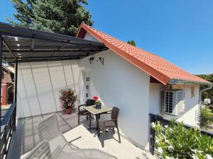 a patio with a table and chairs on a house at Igali Varázs Apartman 2 perc a fürdőtől in Igal