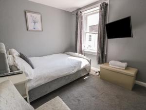a small bedroom with a bed and a window at Fleet Townhouse in Castle Douglas
