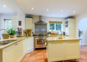 a large kitchen with white cabinets and a sink at Forest Getaway in Slough