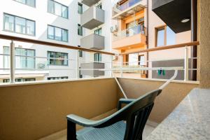 a chair on a balcony with a building at Marea 1 in Pomorie