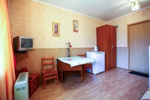 a kitchen with a table and a refrigerator and a tv at Novosel in Ufa