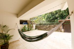 a hammock in a room with a patio at Pousada SANRICK in Guarujá