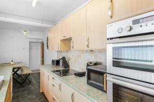 a kitchen with white cabinets and a stove top oven at Contractor Stays, Newly Renovated, Free Parking, Sleep 7 in Wallasey