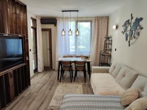 a living room with a couch and a table at Студио Sand, к-с Нестинарка in Tsarevo