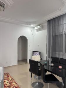 a living room with a black table and chairs at Jinene logement in Yasmine