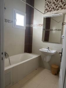 a bathroom with a bath tub and a sink at Jinene logement in Yasmine