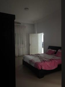 a bedroom with a bed with pink sheets and a window at Jinene logement in Yasmine +9 photos