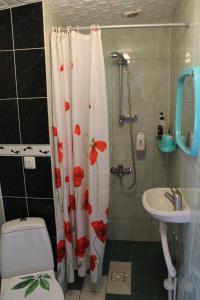 a bathroom with a shower curtain with a toilet and a sink at Aikarali Home Accommodation in Haapsalu