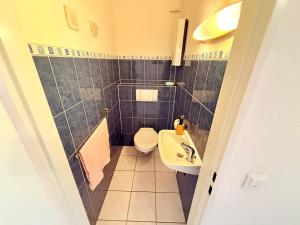 a small bathroom with a toilet and a sink at Altmodische 3 Zimmer Wohnung in Monheim +22 photos