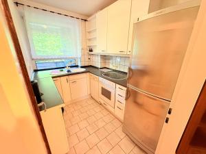 a kitchen with a stainless steel refrigerator and a window at Altmodische 3 Zimmer Wohnung in Monheim