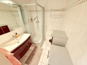 a white bathroom with a sink and a shower at Altmodische 3 Zimmer Wohnung in Monheim +24 photos