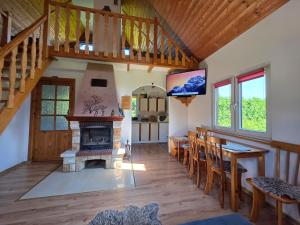 a living room with a staircase and a fireplace at Domek pod Czulnią in Uherce Mineralne