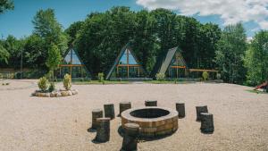 a building with a fire pit in the middle of a park at A-frame Marisa Vadu Crisului in Vadu Crişului