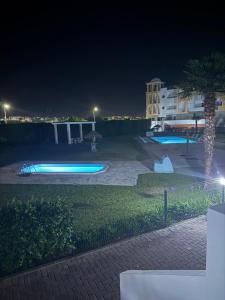 un estacionamiento por la noche con luces azules en Pandora House, en Nazaré
